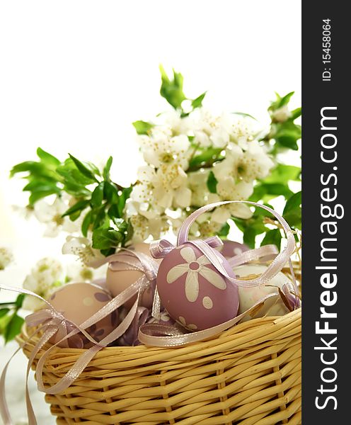 Easter eggs and branch with flowers on white