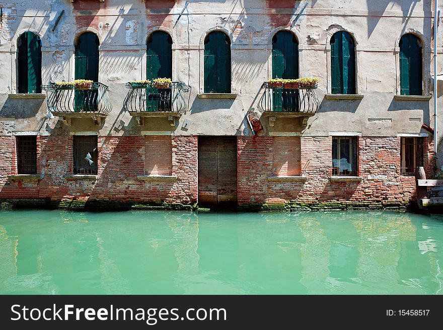 Facade of old venetian house standing in water