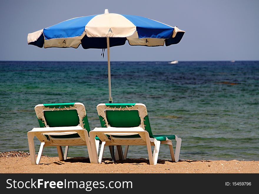 Pair of green beach chairs and parasol. Pair of green beach chairs and parasol