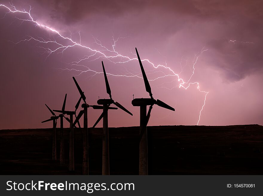 Silhouette of wind turbines on the background of a stormy sky.