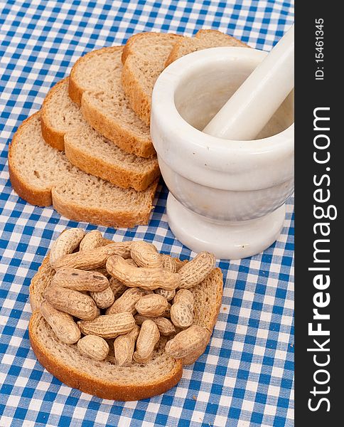 Peanuts on Wheat Bread With Mortar and Pestle. Peanuts on Wheat Bread With Mortar and Pestle