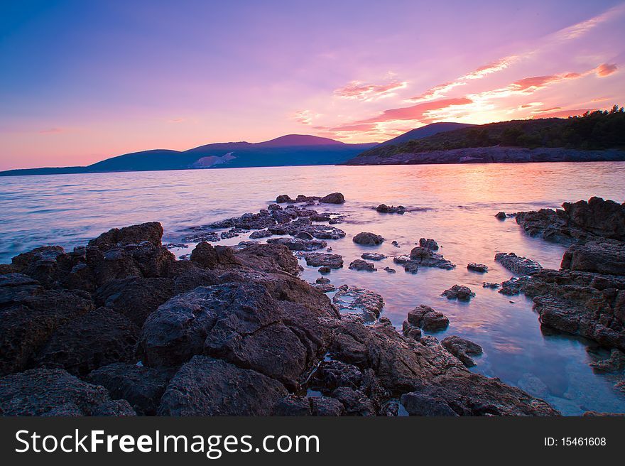 Wonderful summer sunset at the seaside of Montenegro, Adriatic sea. Mountains in the distance are the national border between Montenegro and Croatia. Wonderful summer sunset at the seaside of Montenegro, Adriatic sea. Mountains in the distance are the national border between Montenegro and Croatia