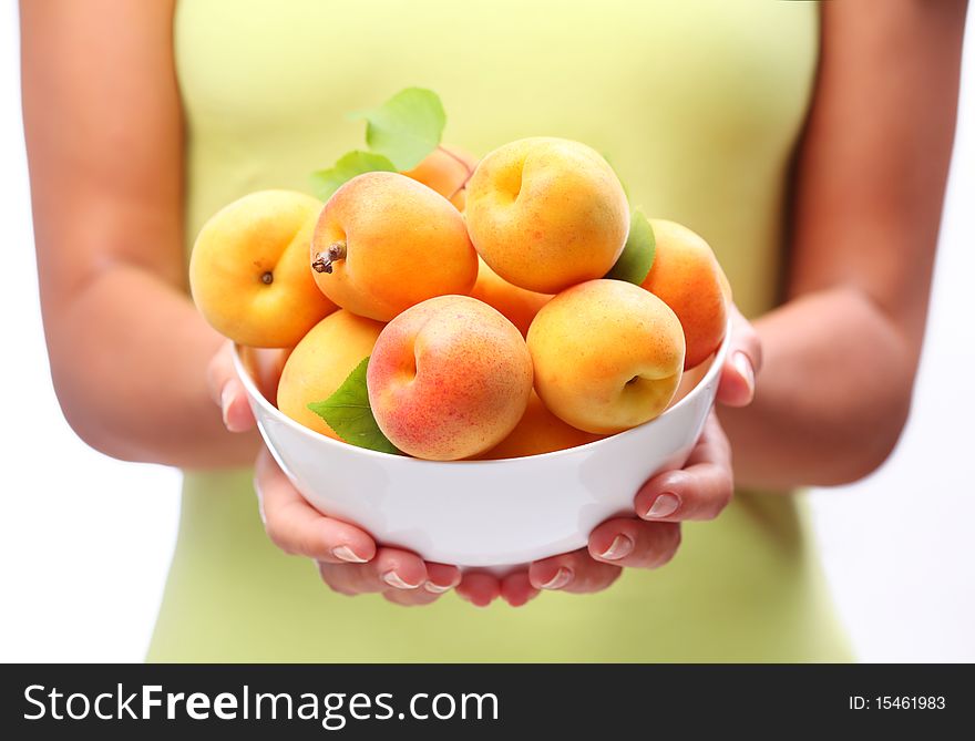Crockery with ripe apricots in woman hands. Crockery with ripe apricots in woman hands.