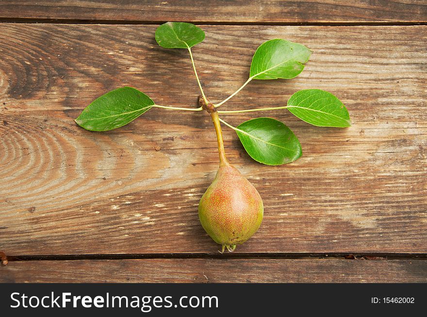 Pear on a wooden table with leaves