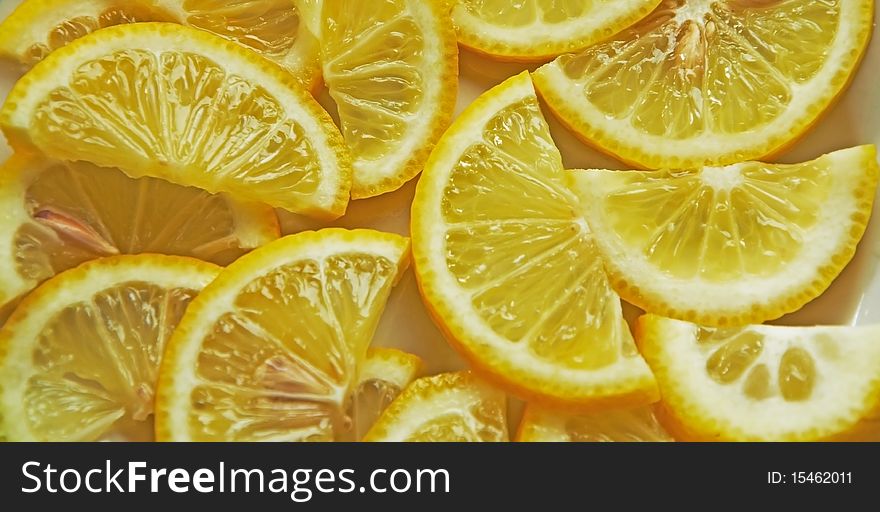 A lot of juicy lemon shares lie on a plate