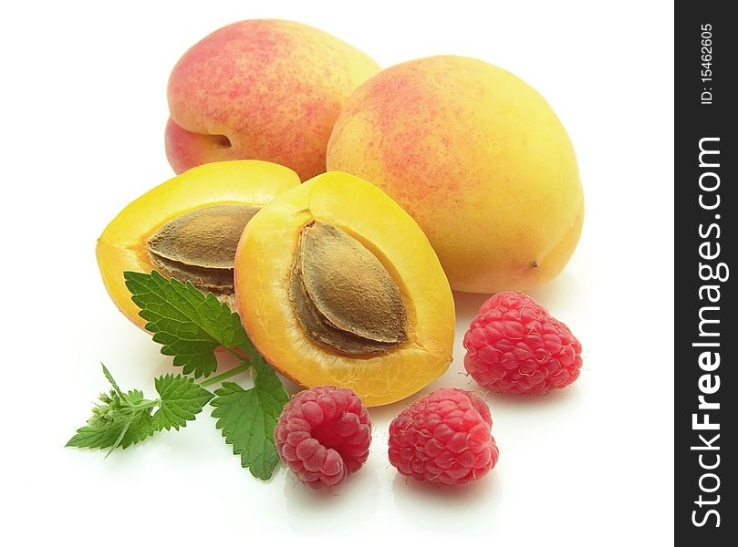 Ripe apricots with berries of a raspberry and a mint branch. Ripe apricots with berries of a raspberry and a mint branch