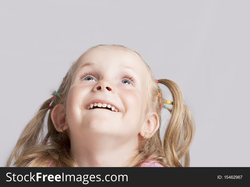 Smiling little blond girl making her head llifted with laughing positive expression isolated. Smiling little blond girl making her head llifted with laughing positive expression isolated