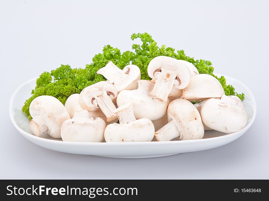 Group of champignons on white plate with parsley. Group of champignons on white plate with parsley