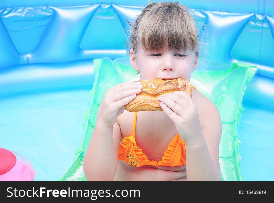 Girl eating biscuits in the pool