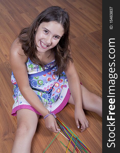 Young girl playing mikado on the floor