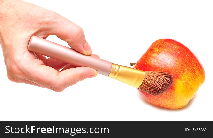 Hand paints with brush this apple in red colour