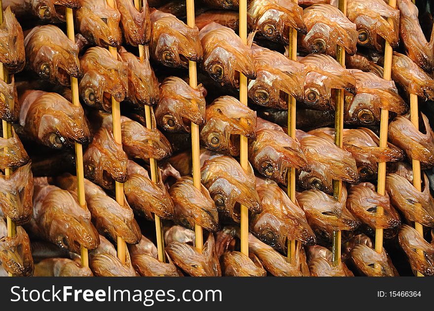 Barbecued fish on skewers close up