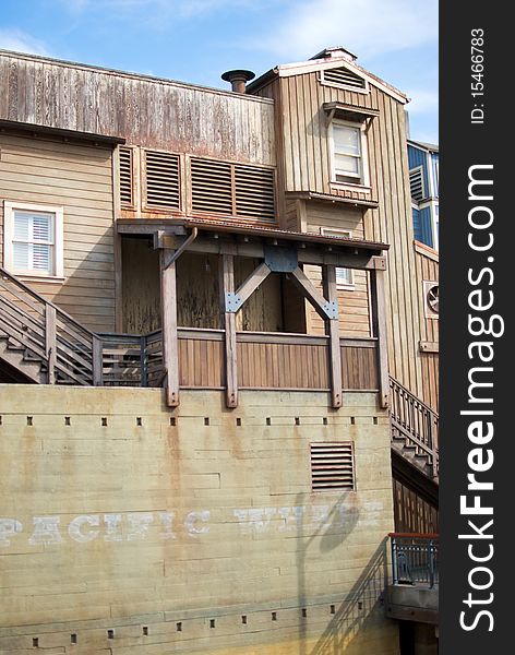 A vertical shot of an old, rundown cannery row building built on a wharf. A vertical shot of an old, rundown cannery row building built on a wharf