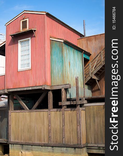 A vertical shot of an old, rundown cannery row building with a single window. A vertical shot of an old, rundown cannery row building with a single window