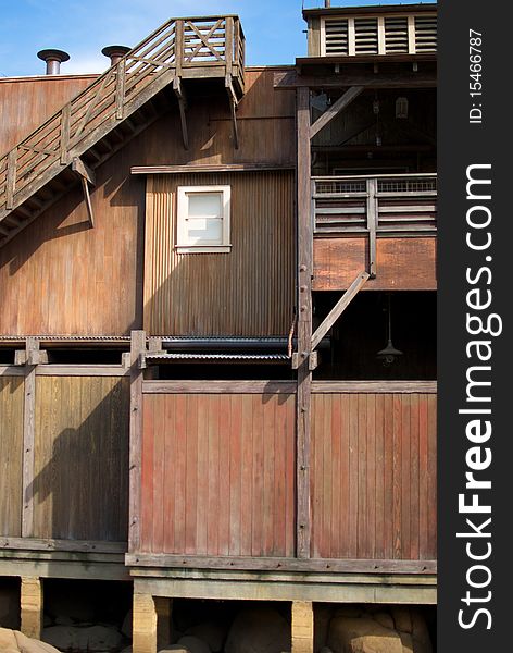 A vertical shot of an old, rundown cannery row building with a single window. A vertical shot of an old, rundown cannery row building with a single window