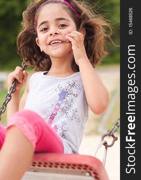 Lovely girl on a swing in the park