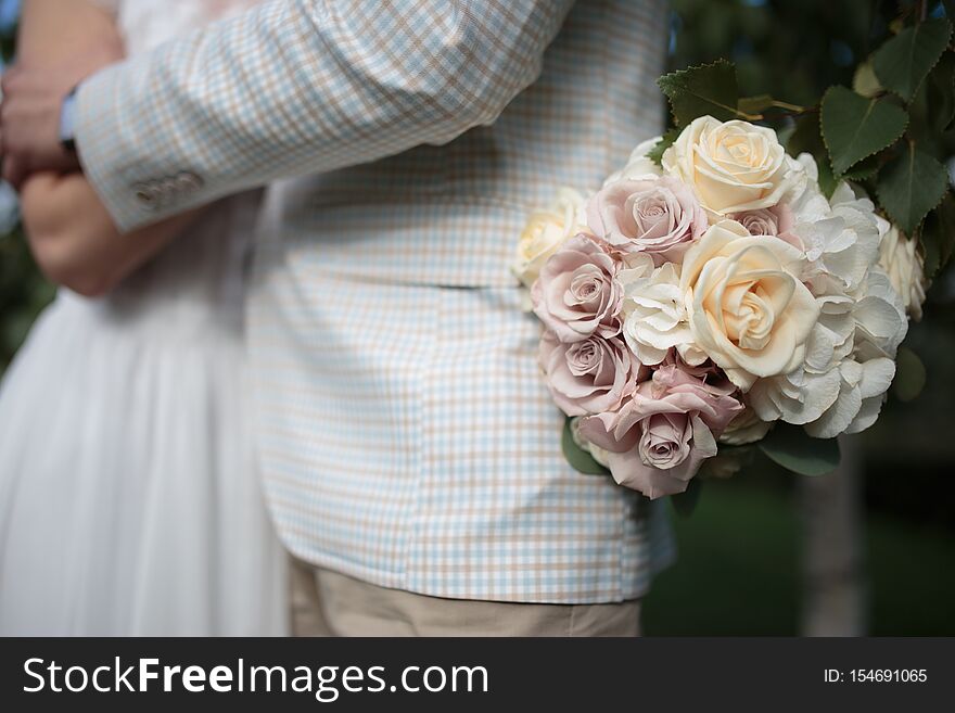 Beautiful wedding bouquet of flowers in the hands of the bride.