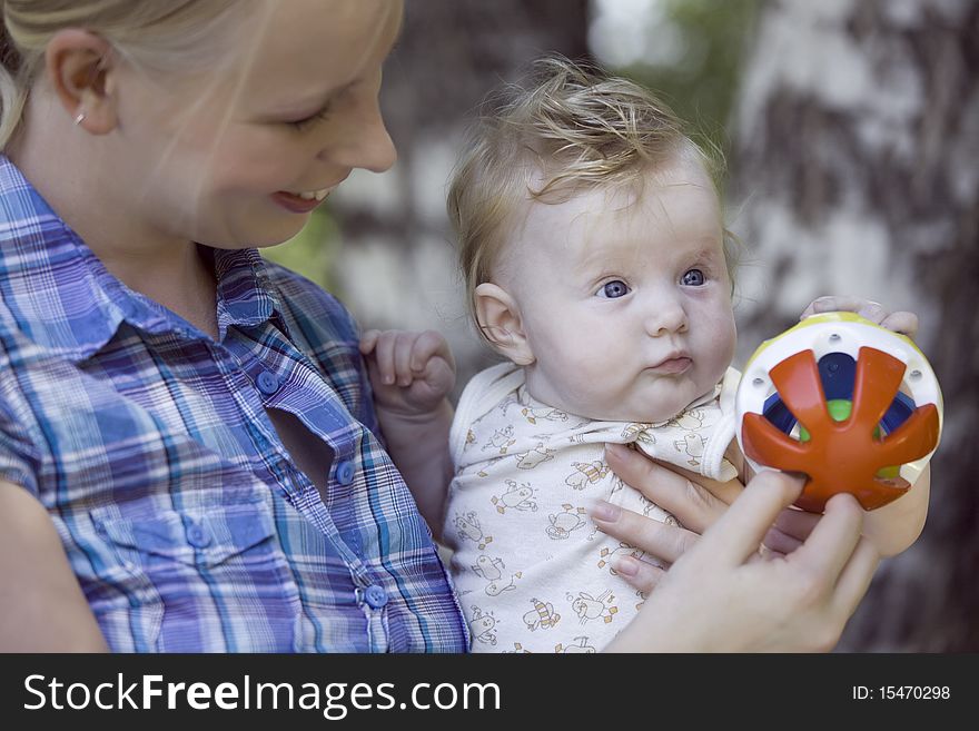 Happy mother playing with her baby outdoors