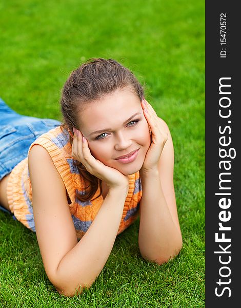 Attractive caucasian girl on green lawn looking at camera. Attractive caucasian girl on green lawn looking at camera