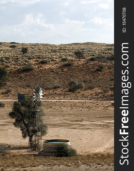 Kalahari red dune and windmill in the Nossob River in the Kgalagadi Transfrontier Park in South Africa and Botswana