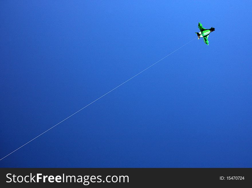 Green kite flying under the clear sky. Green kite flying under the clear sky