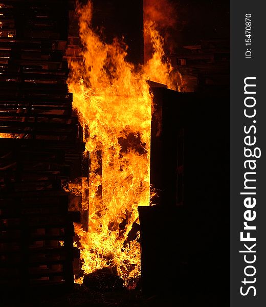 Flames burning wooden pallets at a bonfire night celebration