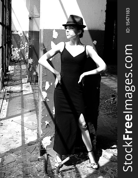 Black and white photography with beautiful teenager girl presenting elegant collection in demolished construction, broken windows in background. Black and white photography with beautiful teenager girl presenting elegant collection in demolished construction, broken windows in background