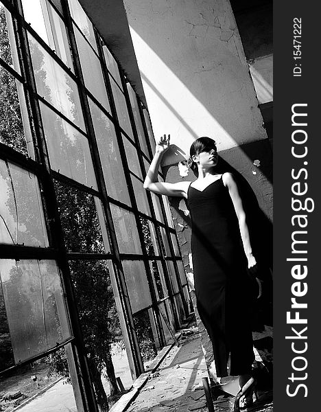 Black and white photography with beautiful teenager girl presenting elegant collection in demolished construction, broken windows in background. Black and white photography with beautiful teenager girl presenting elegant collection in demolished construction, broken windows in background