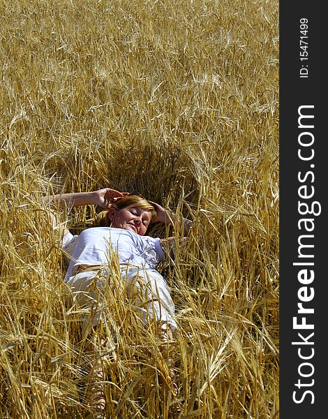 Woman lying in a wheaten field. Woman lying in a wheaten field