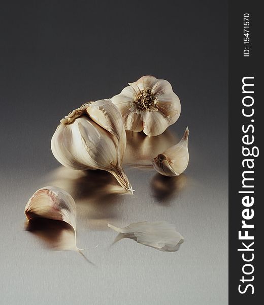 Garlic cloves on reflective metalic surface