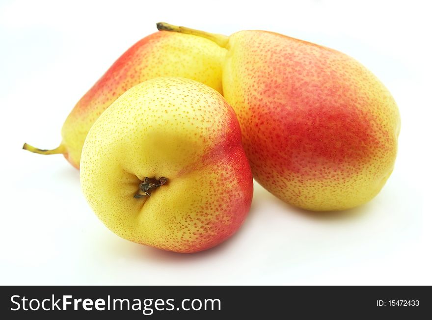 Three ripe yellow pears on a white background