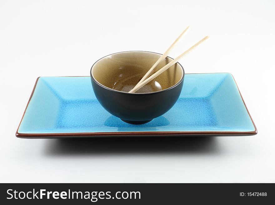 Traditional oriental table setting with chopsticks, rice bowl, and plate. Traditional oriental table setting with chopsticks, rice bowl, and plate.