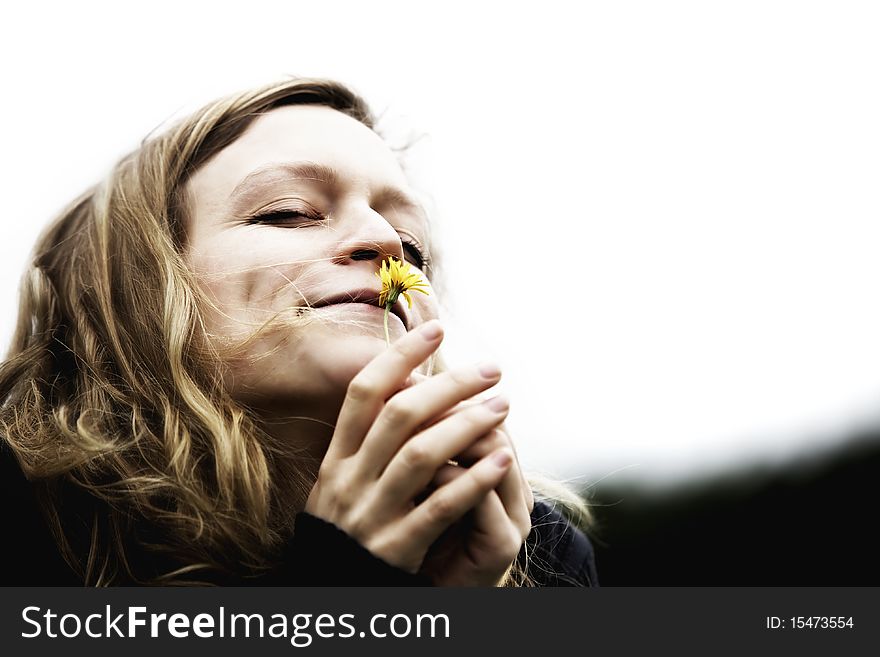 Happy girl inhaling the essence of a beautiful flower. Happy girl inhaling the essence of a beautiful flower.