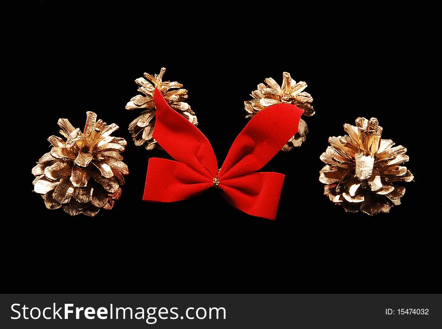 Christmas decoration from four fir-cone and a red bow
on black background. Christmas decoration from four fir-cone and a red bow
on black background.