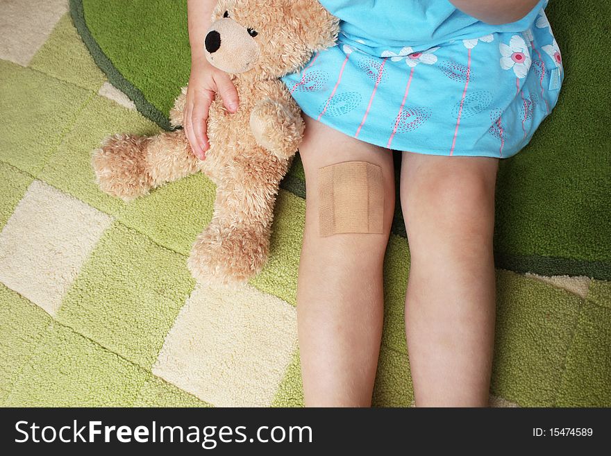 Girl With Plaster On Knee Holiding Teddy Bear