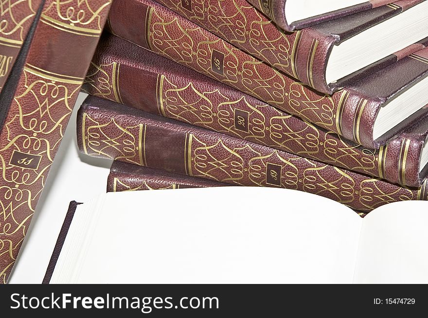 This image shows a collection of old books, stacked with open, showing a blank page. This image shows a collection of old books, stacked with open, showing a blank page