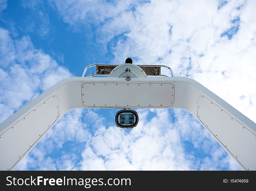 The radar mast of a modern boat against a cloudy sky. The radar mast of a modern boat against a cloudy sky.