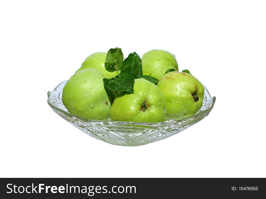 Large green apples are in a crystal bowl. Large green apples are in a crystal bowl.
