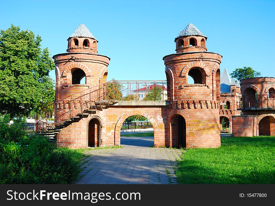 Brick towers connected by the bridge in park