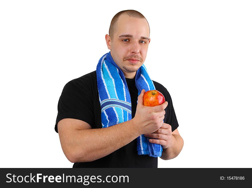 Young sportsman man holds red apple on white background