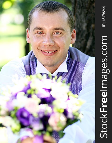 Portrait of the happy man in summer park