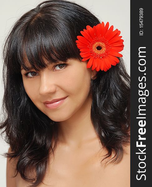 Young beautiful woman with red flower