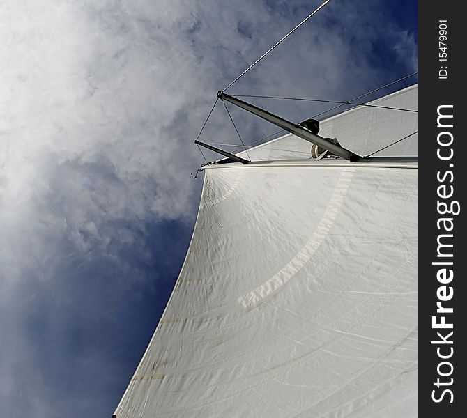 Sail from sailboat against blue sky, sun and clouds. Square format, wide angle. Sail from sailboat against blue sky, sun and clouds. Square format, wide angle.