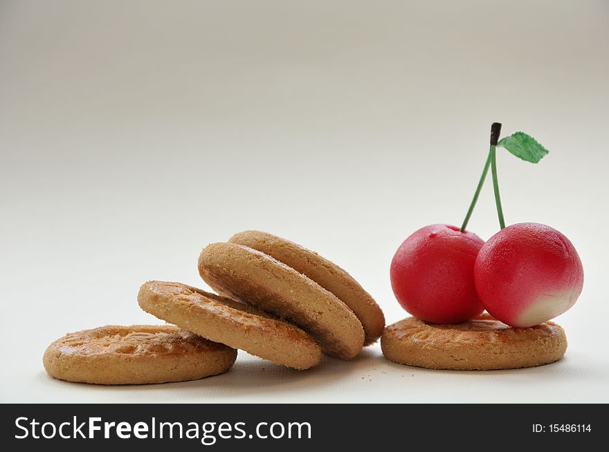 Cherries with biscuits on a white background