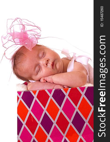 Baby in a colorful gift box with bow on her head. Baby in a colorful gift box with bow on her head.