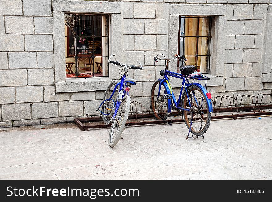 Two bikes stand by a wall