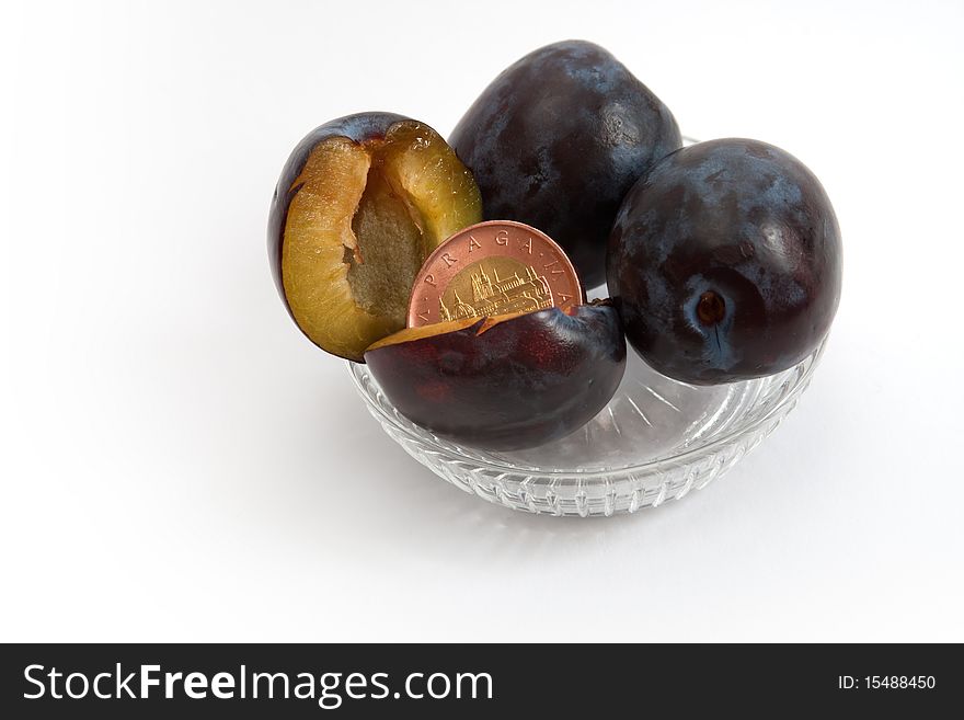 A coin in a plum representing a surprising income, a fruit of hard work. A coin in a plum representing a surprising income, a fruit of hard work.