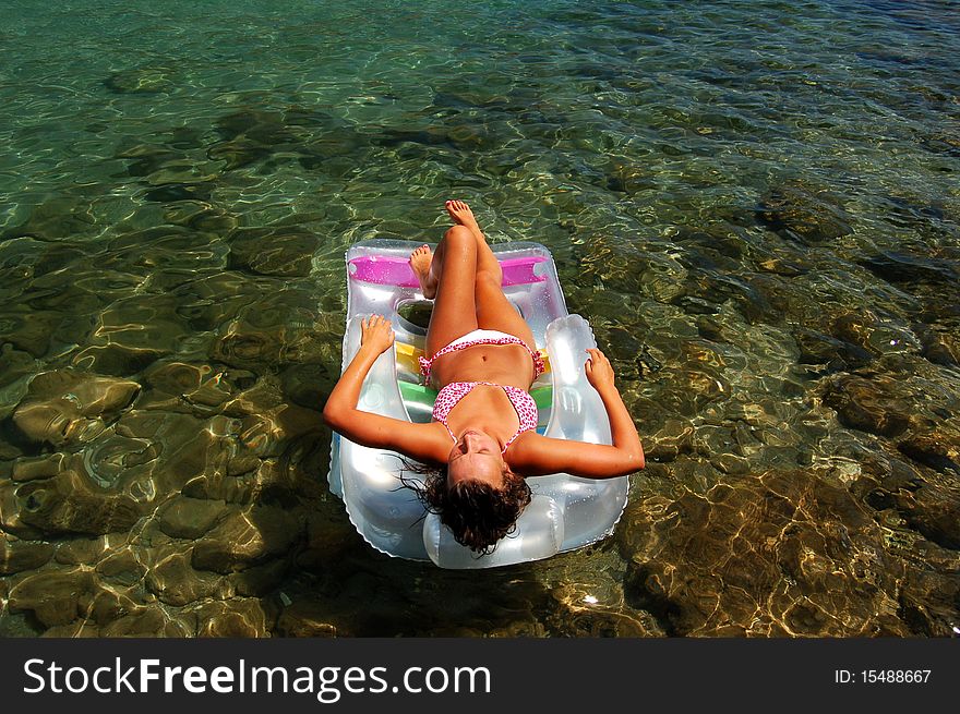 A girl sunbathing on a mattress in Adriatic waters in Montenegro