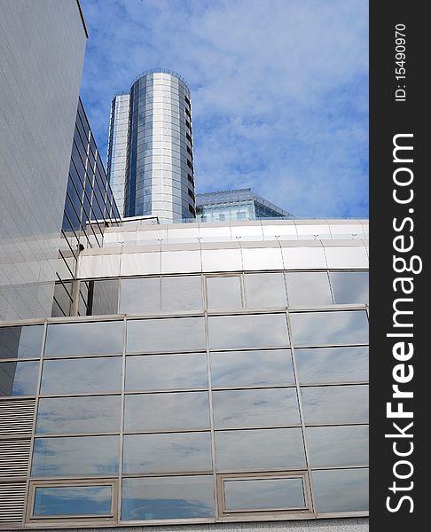 The modern task with a glass tower against the blue sky