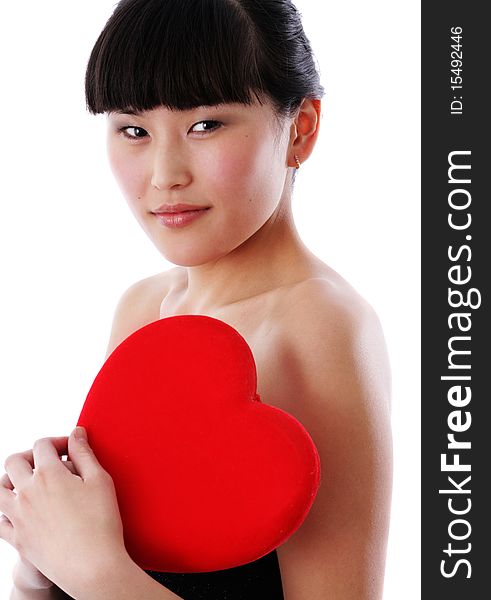 Portrait of a young woman holding a red heart and day dreaming over white background. Portrait of a young woman holding a red heart and day dreaming over white background